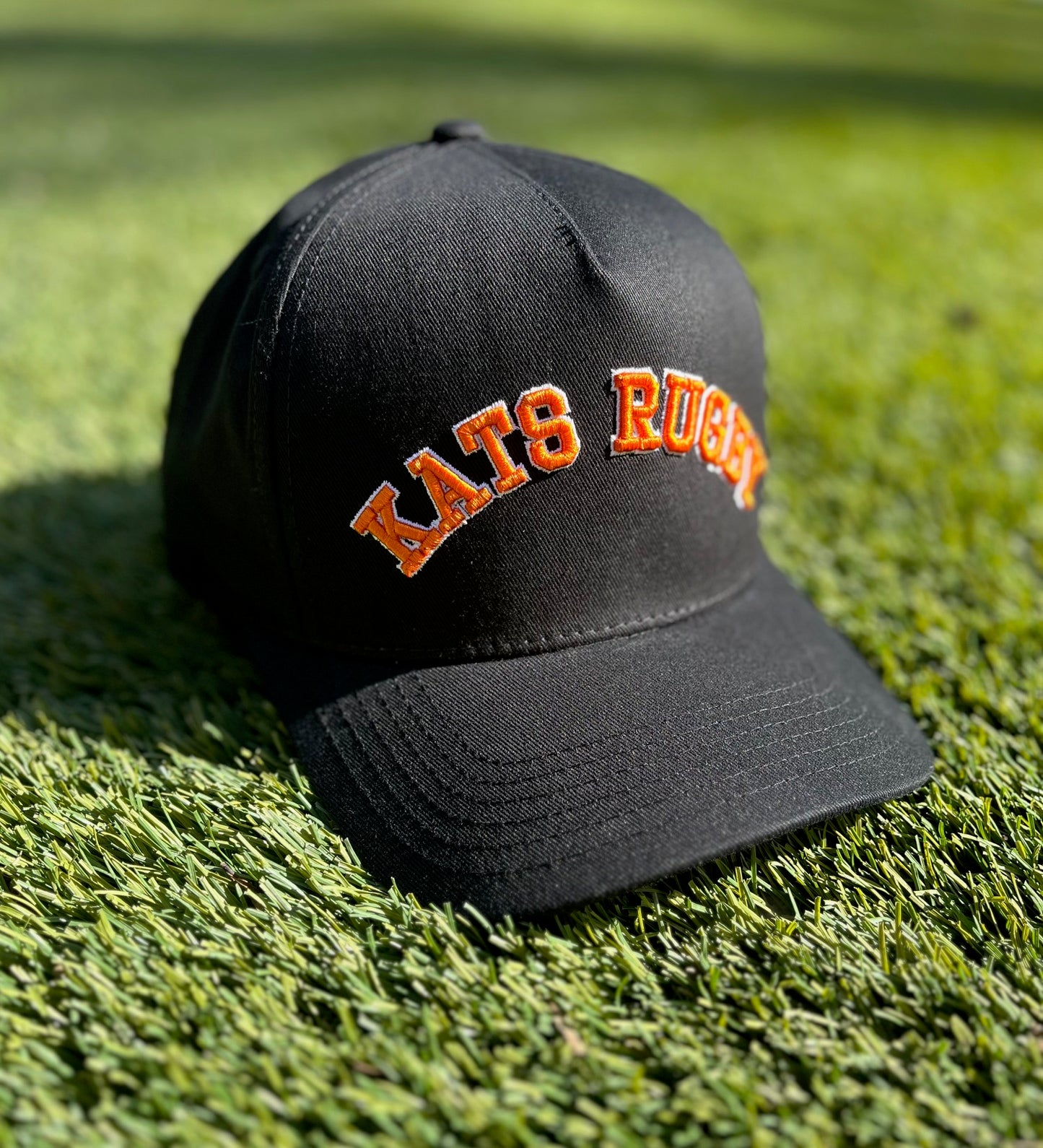 Kats Rugby - Black Hat with Orange Stitching and White Outline | Pre-Curved Snapback