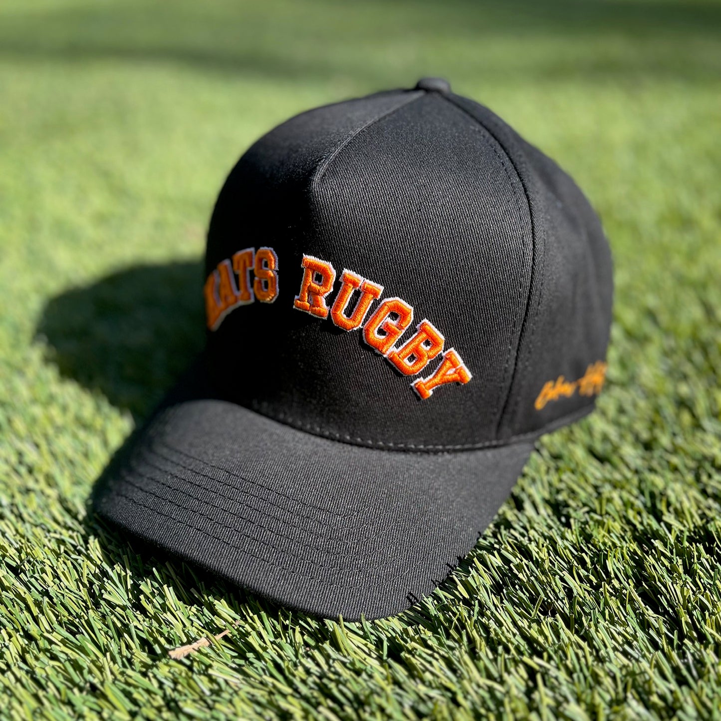 Kats Rugby - Black Hat with Orange Stitching and White Outline | Pre-Curved Snapback